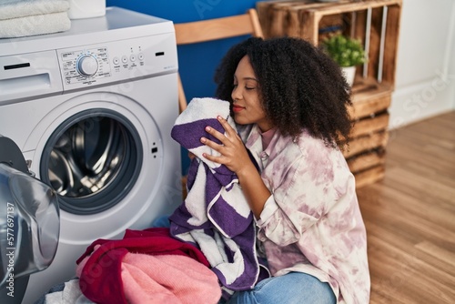 Young african american woman smiling confident washing clothes at laundry