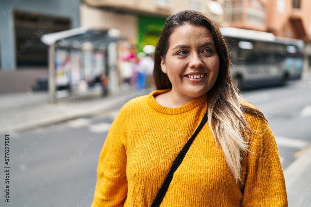 Young beautiful plus size woman smiling confident looking to the side at street