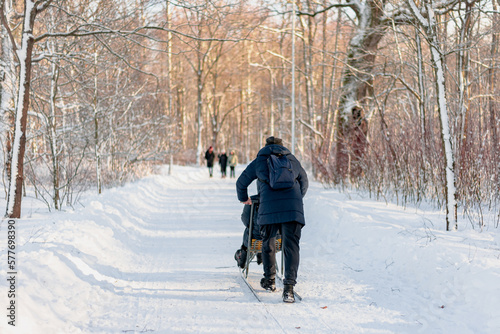A man on a Finnish sleigh carries a woman through a winter park