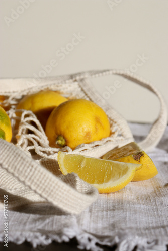 Fototapeta Naklejka Na Ścianę i Meble -  close up of fresh lemons in cotton eco string bag