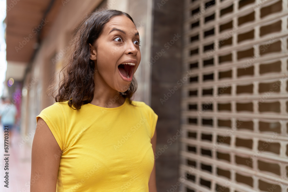 Young african american woman standing with surprise expression at street