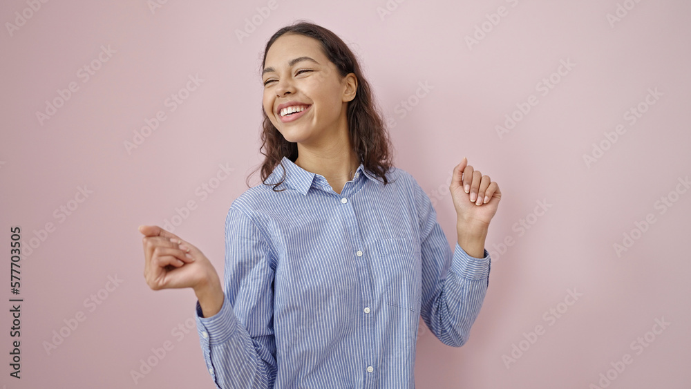 Young beautiful hispanic woman smiling and dancing over isolated pink background Young beautiful hispanic woman smiling and dancing over isolated pink background