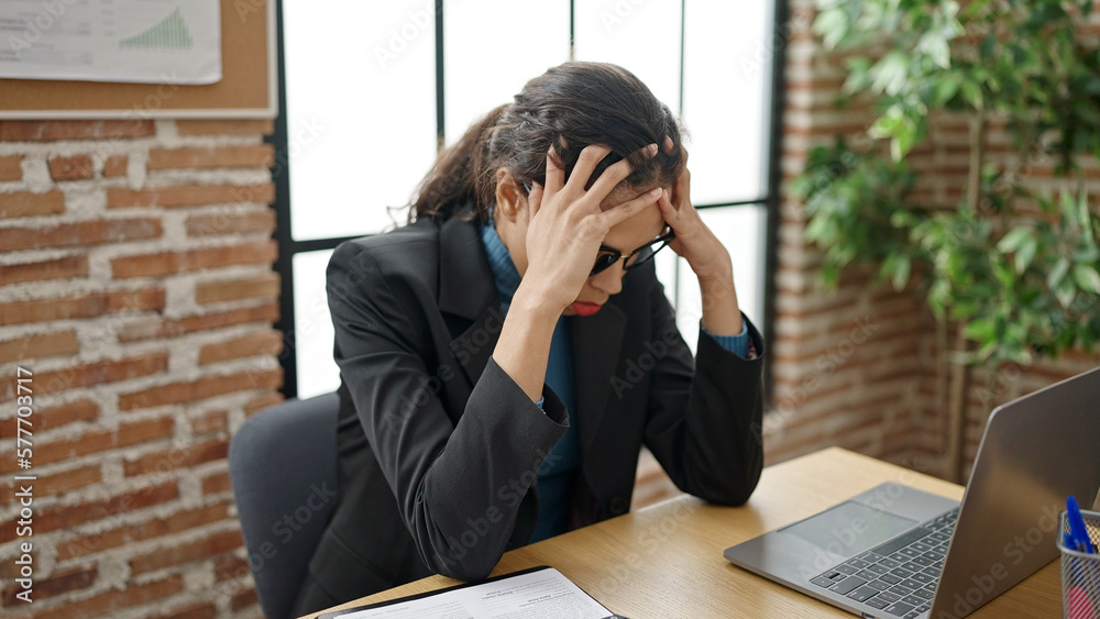 Young beautiful hispanic woman business worker stressed using laptop at office Young beautiful hispanic woman business worker stressed using laptop at office