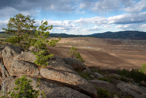 plowed field, arable land, among the rocks, blue sky with clouds, landscape
