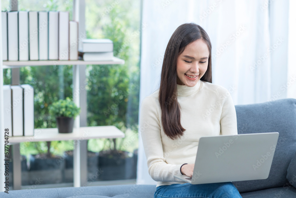 Portrait of Asian young woman doing with computer notebook with happy in love moment in living room Portrait of Asian young woman doing with computer notebook with happy in love moment in living room