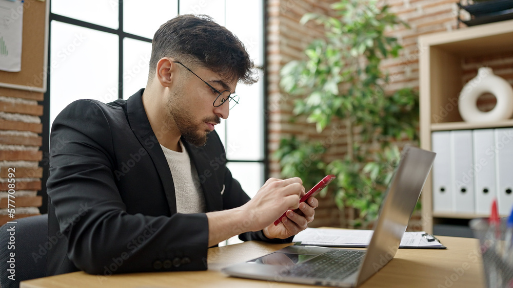 Young arab man business worker using laptop and smartphone at office Young arab man business worker using laptop and smartphone at office