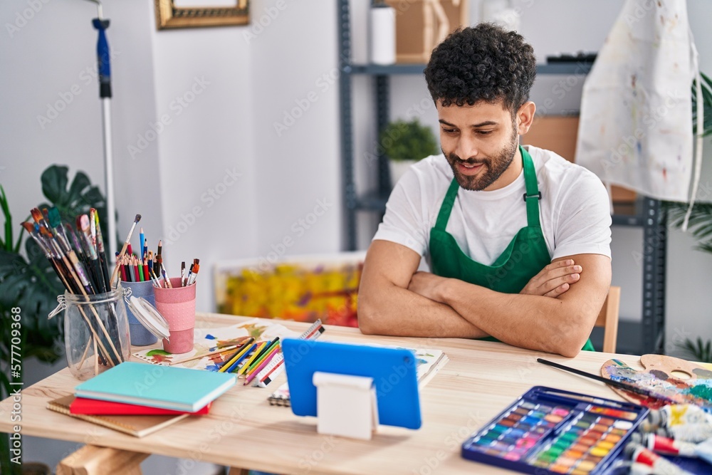 Naklejka premium Young arab man artist smiling confident having video call at art studio