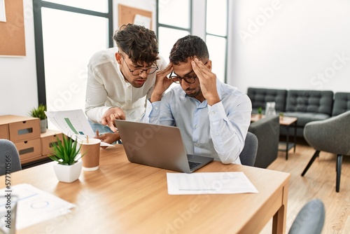 Two hispanic men business workers arguing at office