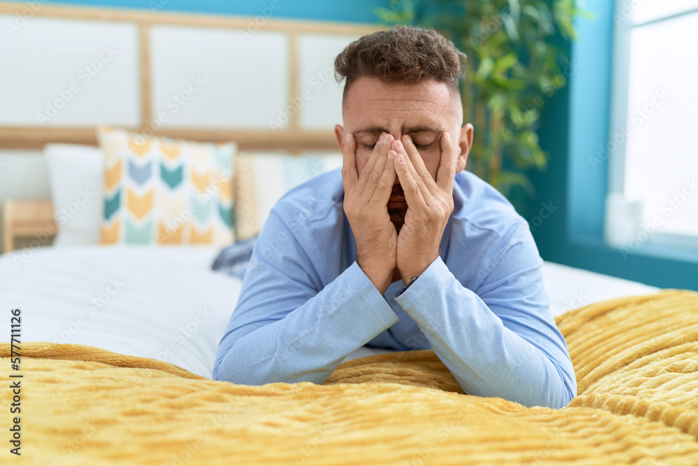 Young hispanic man stressed lying on bed at bedroom Young hispanic man stressed lying on bed at bedroom
