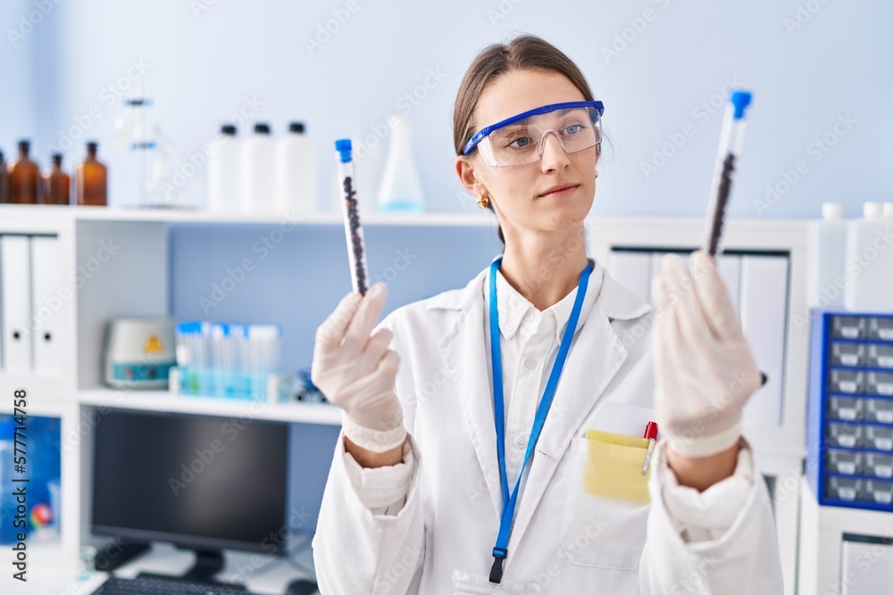 Young caucasian woman scientist holding test tubes at laboratory Young caucasian woman scientist holding test tubes at laboratory