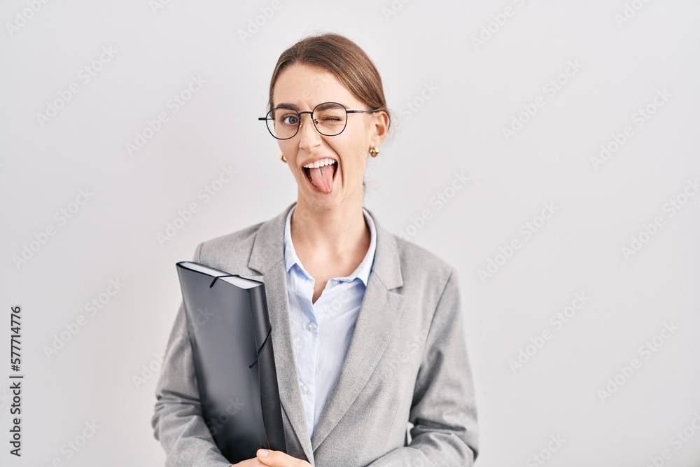 Young caucasian woman wearing business clothes and glasses sticking tongue out happy with funny expression. emotion concept.
