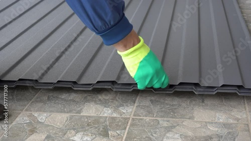 Roof metal profile,The work of a man in the production of corrugated board,
put roofing sheets in a stack