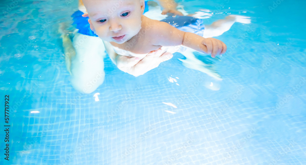 Foto de Adorable baby girl enjoying swimming in a pool with her mother