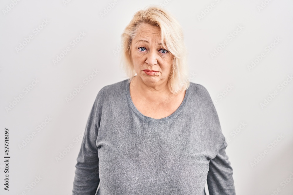 Middle age caucasian woman standing over white background depressed and worry for distress, crying angry and afraid. sad expression. Middle age caucasian woman standing over white background depressed and worry for distress, crying angry and afraid. sad expression.