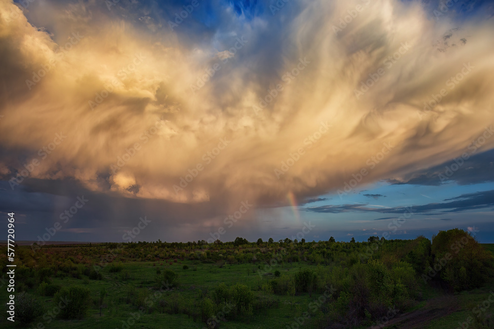 storm cloud after rain over the valley, and a rainbow