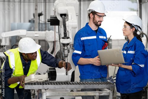 Male industrial engineer manager working with engineering team at production factory in safety equipment technology. Manufacturing technician meeting brainstorming with colleague at workshop facility