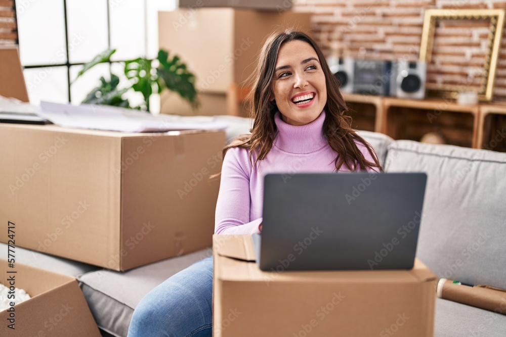 Young hispanic woman smiling confident using laptop at new house Young hispanic woman smiling confident using laptop at new house