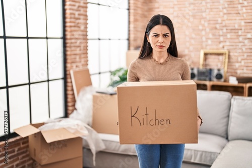 Young woman moving to a new home holding box skeptic and nervous, frowning upset because of problem. negative person. © Krakenimages.com