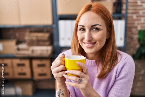 Young caucasian woman ecommerce business worker drinking coffee at office