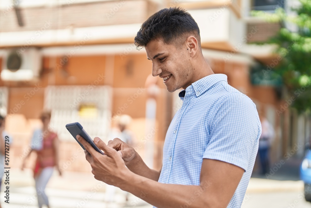 Young hispanic man smiling confident using touchpad at street Young hispanic man smiling confident using touchpad at street
