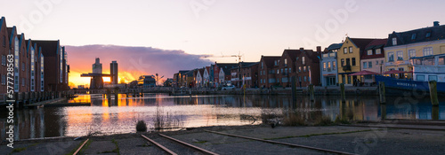 Sonnenuntergang. Im Vordergrund das hafenbecken des Husumer hafen mit Gebäudereihe im Hintergrund photo