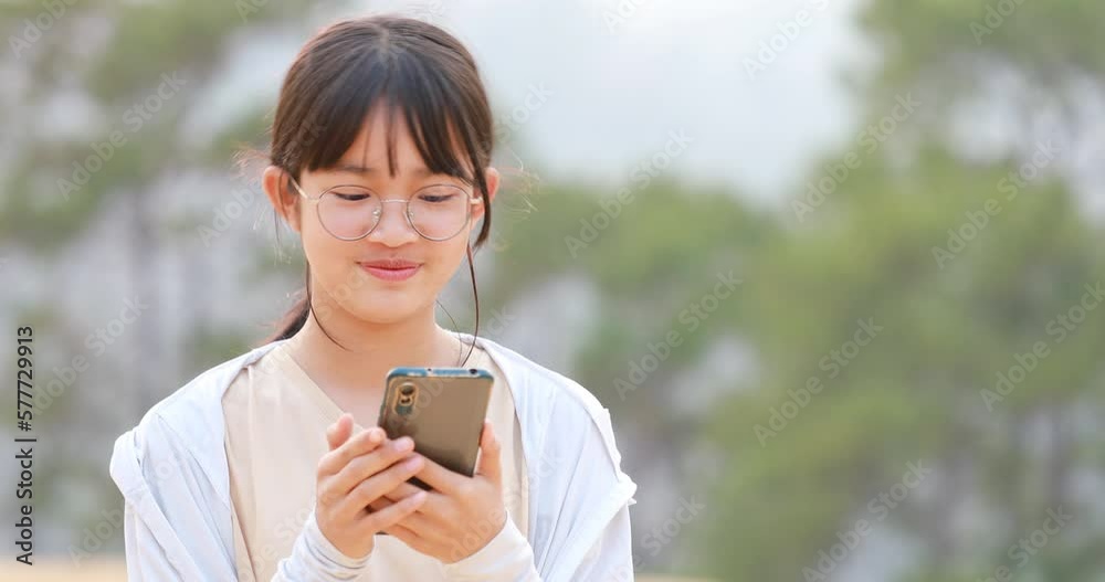 Beautiful Happy teenager girl with glasses sings an audio message on the phone, . Close up portrait outdoors Beautiful Happy teenager girl with glasses sings an audio message on the phone, . Close up portrait outdoors
