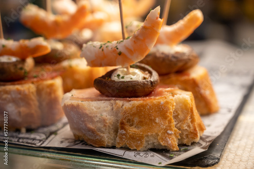 Typical snack of Basque Country  pinchos or pinxtos skewers with small pieces of bread  sea food  eggs  cheese  jamon served in bar in San-Sebastian or Bilbao  Spain