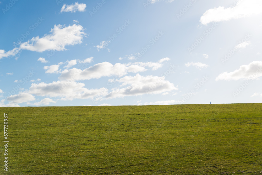 Rasen (Deich) mit blauem Himmel und vereinzelt Wolken Rasen (Deich) mit blauem Himmel und vereinzelt Wolken