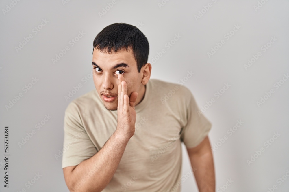 Young arab man wearing casual t shirt hand on mouth telling secret rumor, whispering malicious talk conversation Young arab man wearing casual t shirt hand on mouth telling secret rumor, whispering malicious talk conversation