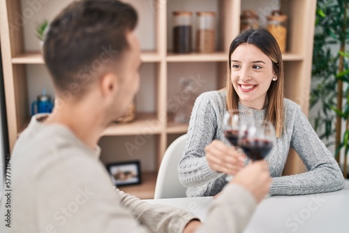 Man and woman couple toasting with glass of red wine at home