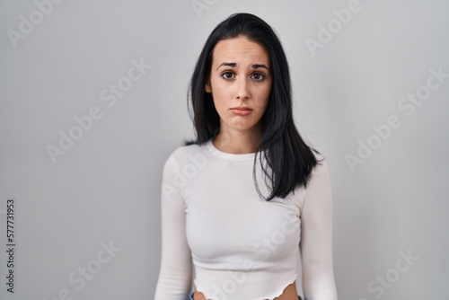 Hispanic woman standing over isolated background depressed and worry for distress, crying angry and afraid. sad expression.