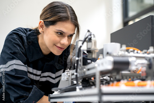 Female electronic engineer examining robotic equipment in engineering laboratory. Computer maintenance technician repairing automated robot hardware technology. Woman expertise in modern industry 4.0