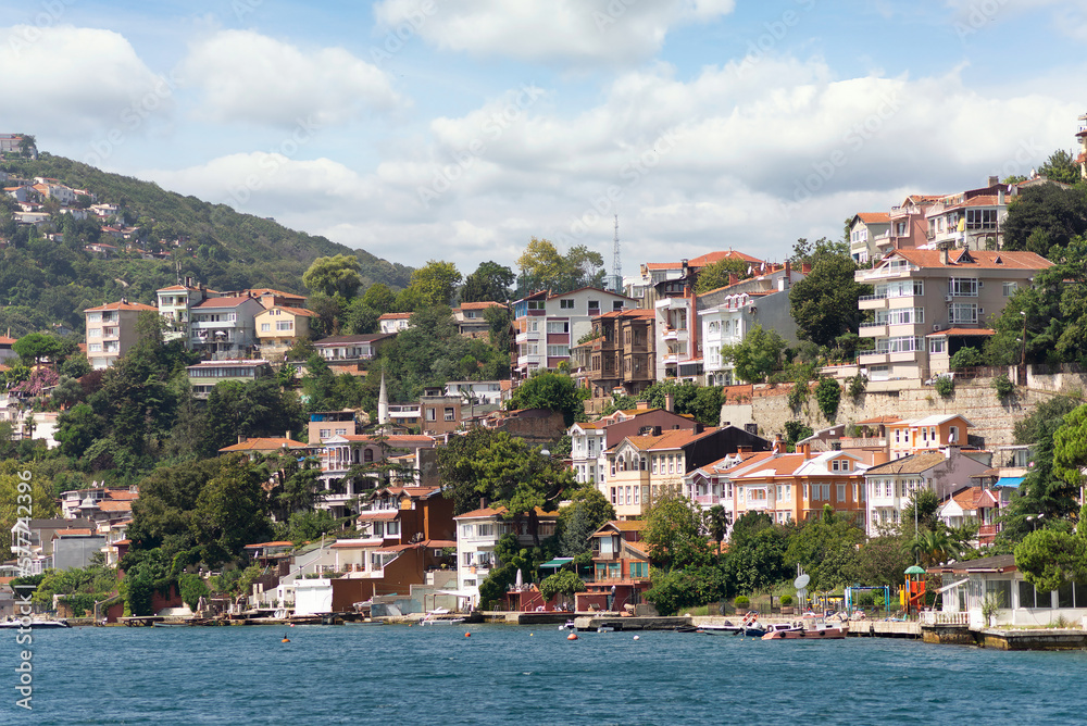 View from the sea of the green mountains of the Europian side of Bosphorus strait, with traditional houses and dense trees in a summer day, Istanbul, Turkey