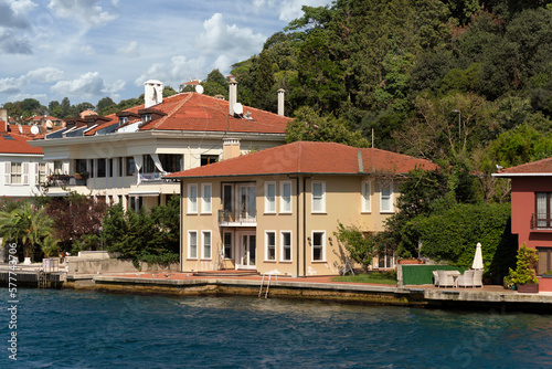 View from Bosphorus strait of the green mountains of the Asian side, with traditional houses and dense trees in a summer day, Istanbul, Turkey