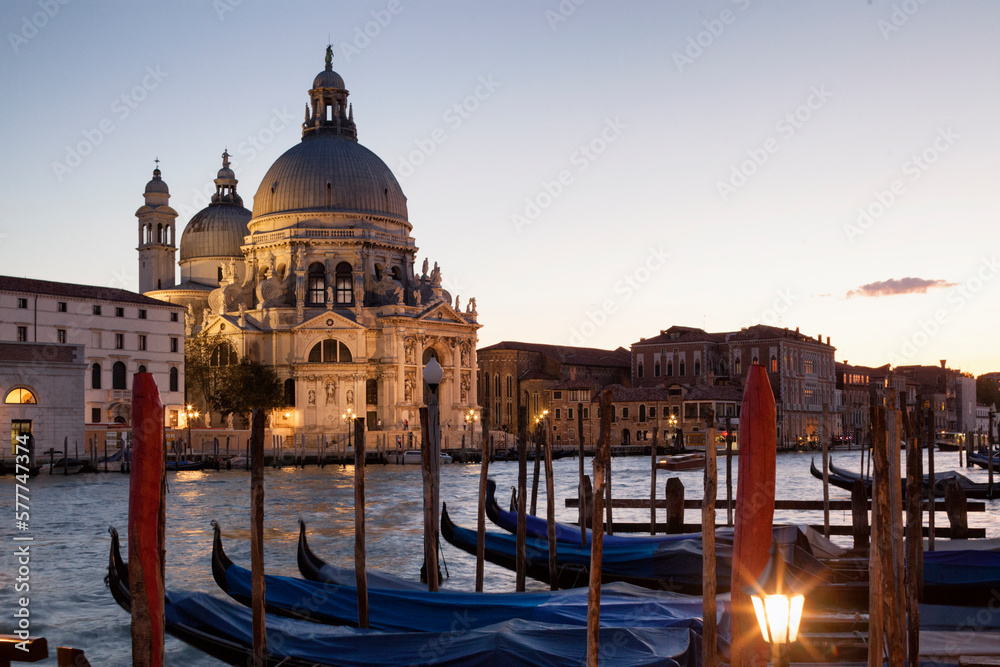 Venezia.Basilica di Santa Maria della Salute al crepuscolo sul Canal Grande con gondole al palo
