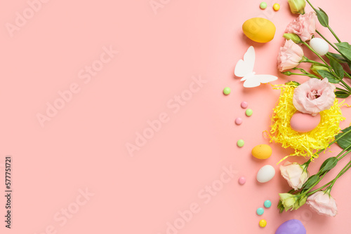 Easter holiday concept with easter eggs and spring flowers on pink background. Top view, flat lay