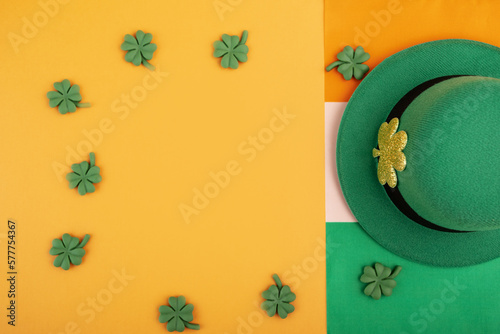 green irish leprechaun hat with shamrocks and irish flag on orange background  saint patrick day banner  irish holiday card  top view