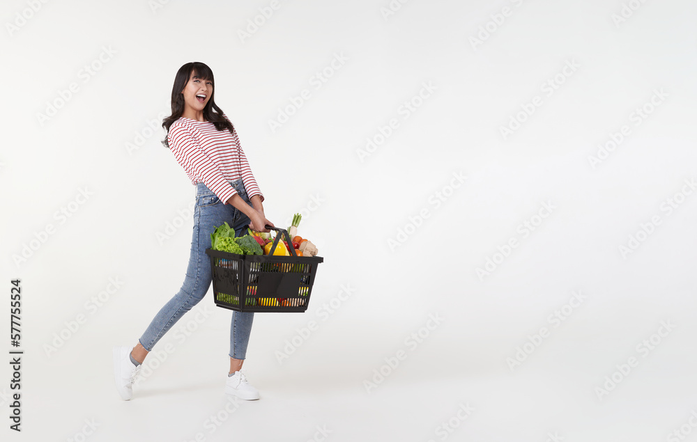 © NaMong Productions - Happy Asian woman holding shopping basket full of vegetables and groceries, studio shot isolated on white background. copy space © NaMong Productions - Happy Asian woman holding shopping basket full of vegetables and groceries, studio shot isolated on white background. copy space