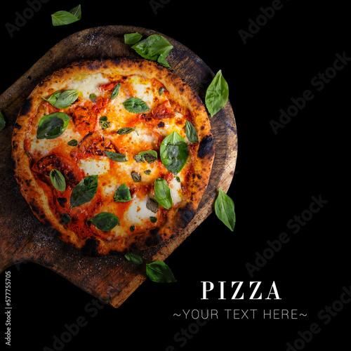 Top view of classic Italian uncut Margherita pizza with tomatoes, mozzarella cheese and fresh basil leaves served on baking shovel. Cheesy pizza isolated on black background with text and copy space