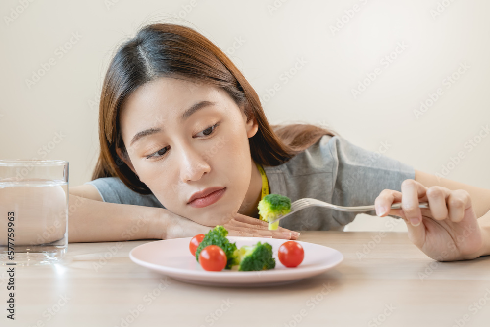Bored woman eat salBored woman eat salad during diet for losing weightweight