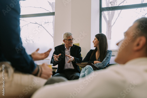 Fotografi An older male business person having a business talk with his young female brune