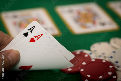 Closeup of hands with two aces, Texas Hold'em Poker gambling concept	

