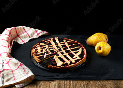 pie and pears are laid out on a black background next to a kitchen towel
