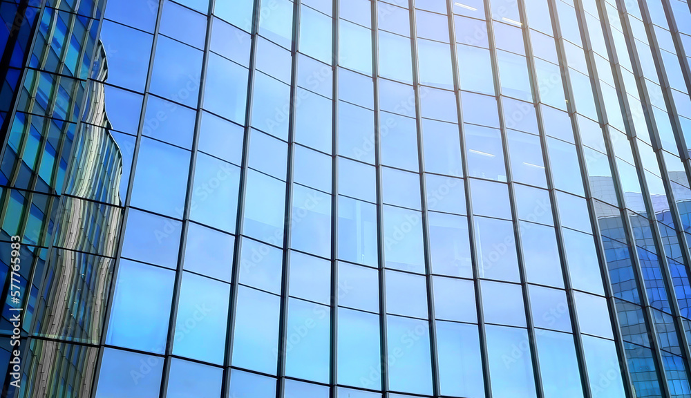 glass buildings reflecting with bright blue sky used as background. modern office building exterior, blue toned image for commercial, business, corporate concept. modern curtain wall. glass buildings reflecting with bright blue sky used as background. modern office building exterior, blue toned image for commercial, business, corporate concept. modern curtain wall.