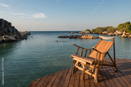 Wooden sunbed at resort patio by sea in morning, Ko Man Klang