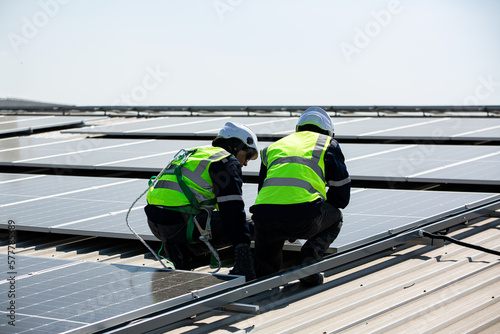 Engineer service check installation solar cell on the roof of factory on the morning.