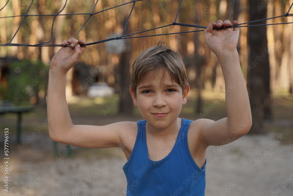 Teenage sports fashion. Photo of smiling teen boy in sportswear near volleyball net. Teenage sports fashion. Photo of smiling teen boy in sportswear near volleyball net.