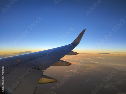 Photography of the plane's wing through the window, beautiful evening in the air