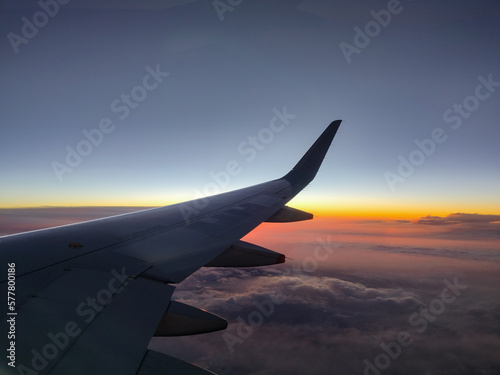 Photography of the plane's wing through the window, beautiful evening in the air