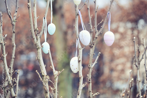 Canvas Print colorful easter eggs hanging on a branch, blurred background